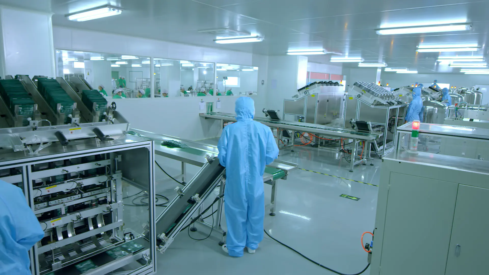 Cleanroom operators working with automated cosmetic production equipment