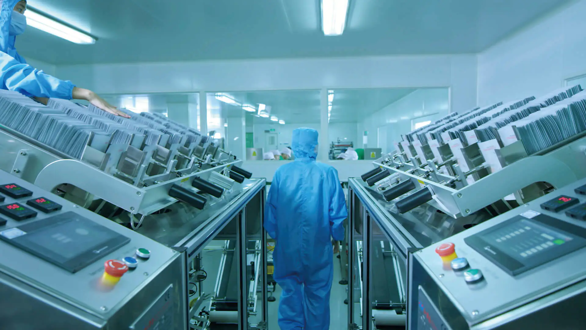Cleanroom operator monitoring automated cosmetic production equipment