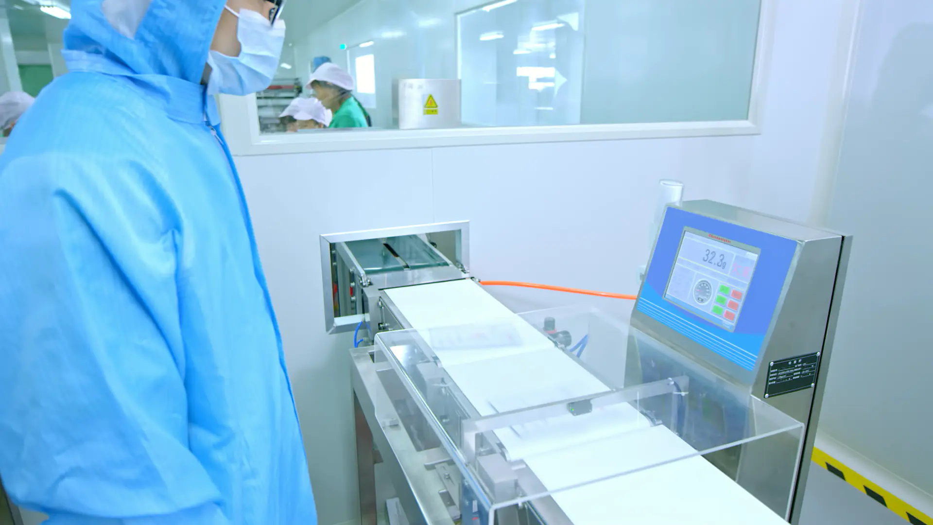 Cleanroom operator monitoring cosmetic production equipment and process parameters